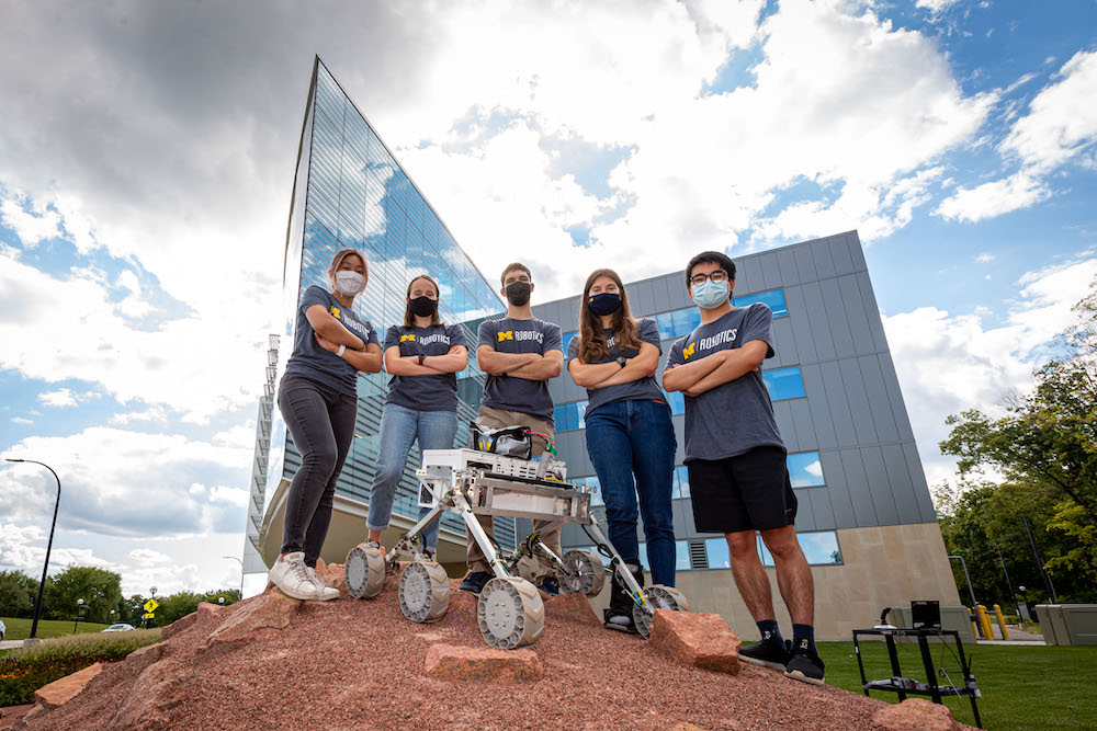 The MRover student team and their rover pose on top of the Mars Yard